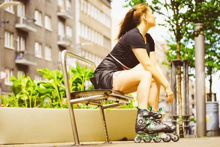 滚筒全自动洗衣机快乐的年轻女子穿着滚冰鞋坐在城里女夏季玩得开心
