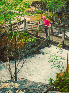 旅游妇女站在桥上挪威Aurlandsfjelet山沿Aurlandsfjellet山的瀑布上享受着暴水SognogFjordan图片