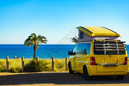 露天面包车屋顶上有帐篷在地中海岸露营在西班牙有棕榈树PerchelesBeach假日和乘汽车回家图片