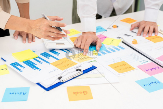 集思广益的商界人士创意团体集思广益使用粘贴笔记在办公桌上或分享想法图片