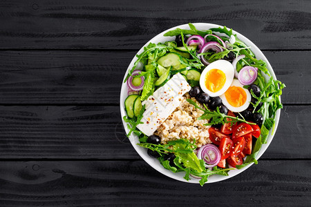 希腊风格的健康早餐碗配有燕麦粥和新鲜蔬菜沙拉包括生黄瓜橄榄番茄奶酪和煮鸡蛋背景图片