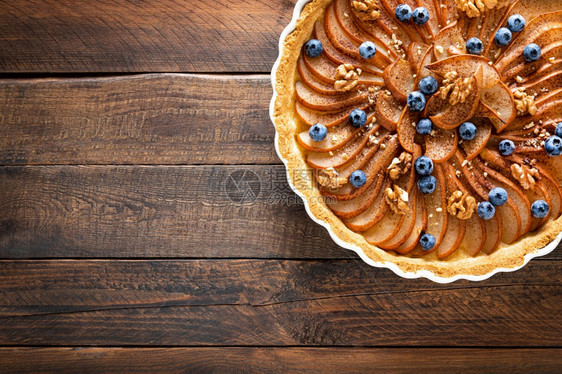 感恩节梨饼派或蛋糕配有新鲜梨蓝莓肉桂和胡桃图片
