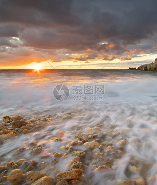 美丽的海景日落时和岩石自然的构成图片