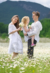 家庭场景快乐的家庭在大卡莫米尔山地草上情感爱和照顾的场景背景