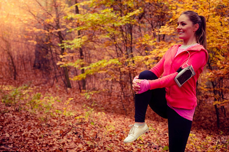 在秋天公园森林露升温女在新鲜空气中锻炼活跃的女孩在森林中伸展图片
