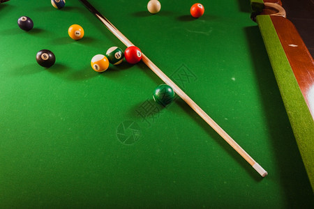 Billiard球和杆粘在绿色桌上池球游戏史努克和坚持在台桌上图片