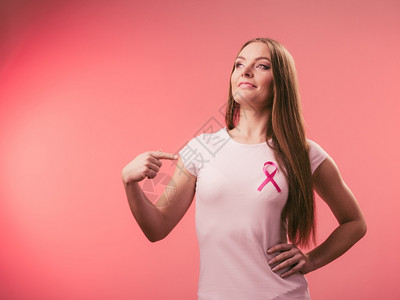 乳房上的粉色妇女癌症丝带保健医药和乳腺癌认识概念工作室拍摄红色背景胸口上的粉色妇女癌症丝带胸口上的粉色妇女癌症丝带图片