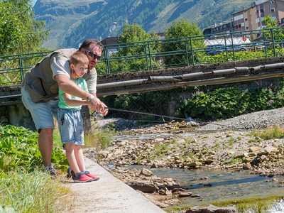 父亲在山上河边教小男孩钓鱼图片