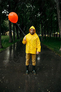 雨天衣橡皮靴巷子里的湿天气孤独雨天带着气球在公园行走的悲哀男人图片