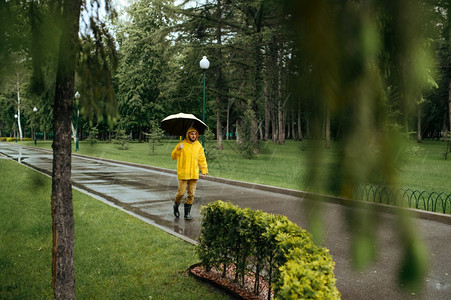 雨天衣和橡皮靴巷子里的湿天气孤独自一人在公园雨日独自一人带着伞在公园行走图片