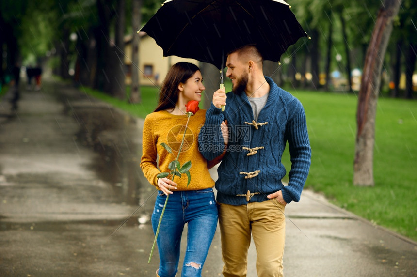 在雨天的夏日公园散步约会的情侣图片