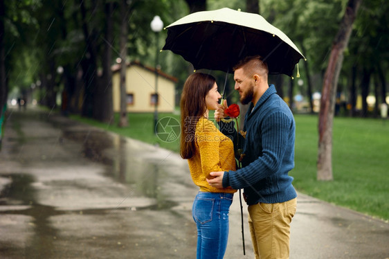 在雨天的夏日公园约会的情侣图片