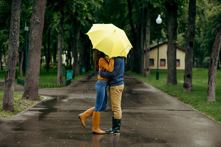 男人和女站在雨伞下浪漫约会在路上小巷里潮湿的天气图片