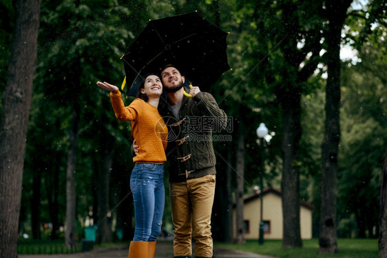 幸福的情侣享受夏天的雨水图片