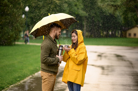 男女在雨中站伞下浪漫约会在路上小巷里潮湿的天气图片