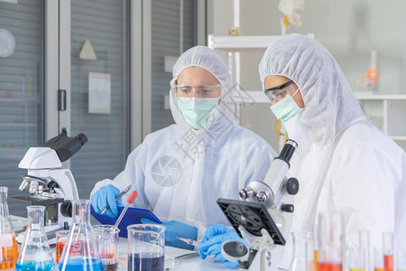 一家西方科学夫妇在实验室或中在技术医学化保健研究实验科学等领域研究测试管以分析和开发共生19疫苗图片