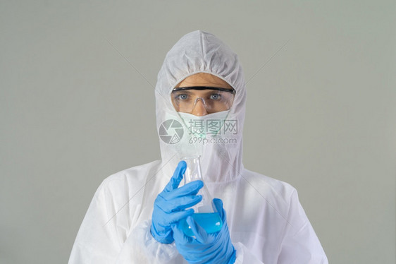 一名西方女科学家身着新冠19套装和面具持有测试管在实验室或分析生物19疫苗用于技术医学化保健科研究图片