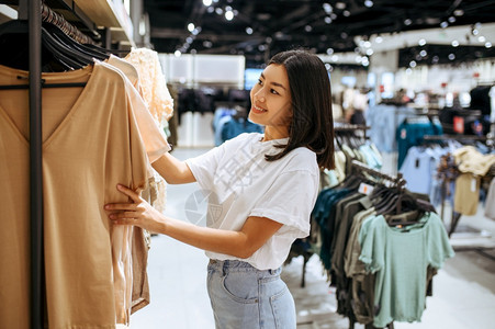 妇女在服装商店中选择衣服女在时装店商购物观光买衣服女在装商店中选择女在商店中选择图片