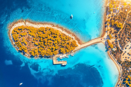 克罗地亚摩尔特岛秋天日落时海湾中美丽小岛的空景象清蓝水橙树山地沙滩船只和游艇坠落的高度景象图片