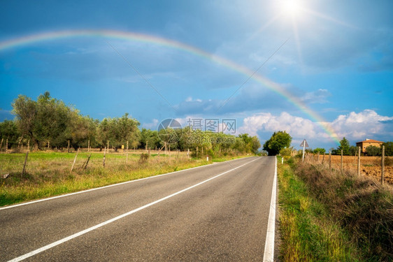 彩虹横跨意大利托斯卡尼的公路和农业景观彩虹横跨公路和农业景观图片