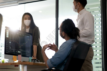 由于科罗纳新冠19大流行三名亚裔商人在办公室重新开张后上午讨论他们的工作佩戴防护面罩止感染新的正常办公室生活概念图片
