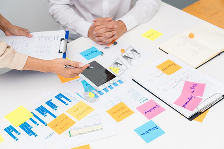 集思广益的商界人士创意团体集思广益使用粘贴笔记在办公桌上或分享想法图片