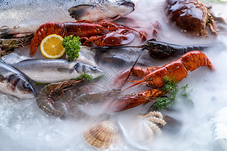 各种新鲜的奢侈海龙虾鲑鱼竹鳄龙虾章和石蟹它们以冰底为背景在海鲜市场上含冰烟图片