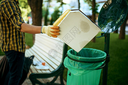 青年志愿者在公园的塑料袋里放垃圾志愿工作男清洁森林生态恢复活方式垃圾收集和回生态护理环境清洁志愿者在塑料袋里放垃圾志愿工作图片