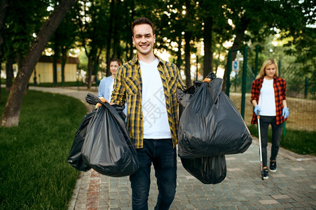 自愿者在公园里持有完整的塑料垃圾袋志愿工作男清洁森林生态恢复活方式垃圾收集和回生态护理环境清洁图片