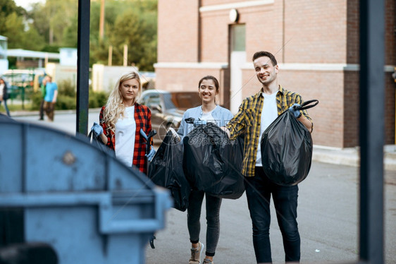 志愿者在户外持有塑料垃圾袋从事志愿工作人们在城市街道上打扫生态恢复活方式垃圾收集和回生态护理环境清洁志愿者在户外持有塑料垃圾袋图片