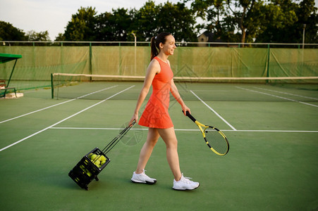 女网球运动员在户外法庭上带球篮子活跃的健康生方式体育比赛运动带球的健身训练女网球运动员带篮子图片