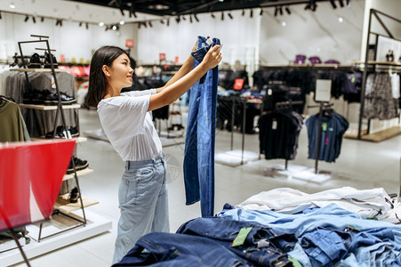 女在服装店中选择牛仔裤女在时装店商购物女在服装店购买时物观光图片