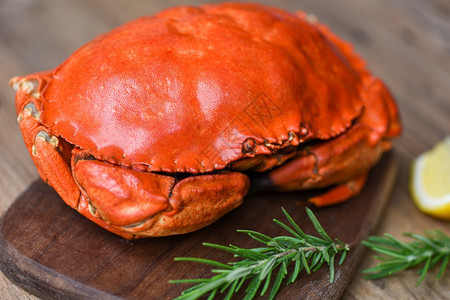 海食贝壳鱼蒸红色螃蟹或煮石头新鲜木板上配有柠檬迷迭香图片
