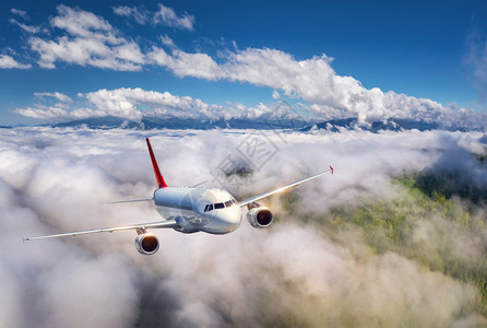 飞机在夏季日落时正飞往云层上空图片
