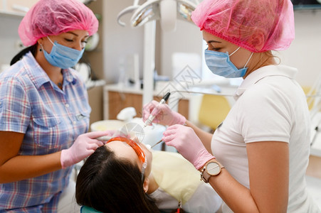 女牙医和助理是门诊口腔科的治疗病人穿制服的医生务工作者药和保健生专业牙齿护理科医生和助理生是诊所的治疗病人图片