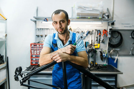 修理车间的自行修理男子在架上摆姿势修理工在车架上摆姿势图片