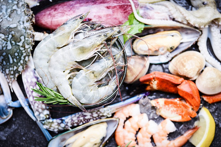 冰上海产食品贝壳鱼冰上冻虾蟹爪冰冻海蛤乌章鱼和在餐馆的贝类配柠檬迷迭香剂和料的新鲜生海自助餐图片