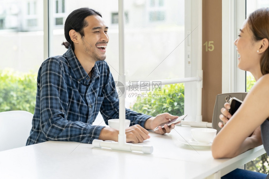 亚洲年轻夫妇在新的普通社会距离餐厅共进晚配有桌垫屏蔽可以减少新冠covid19传染病的感图片