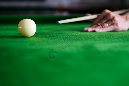 Man手和Cue臂在玩Snooker游戏或准备在绿色球桌上绿色盘上有多彩的Snooker球图片