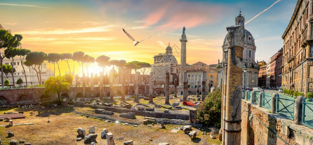 Trajanr日落时在罗马的专栏和教堂图片