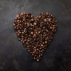 深黑生锈背景的心形咖啡豆平地图片