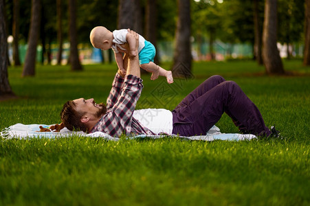 父亲和他的小宝躺在夏天公园的草地上爸和他的小宝躺在夏天公园的草地上父亲和他的小宝躺在公园的草地上父亲和他的小宝躺在公园的草地上父图片