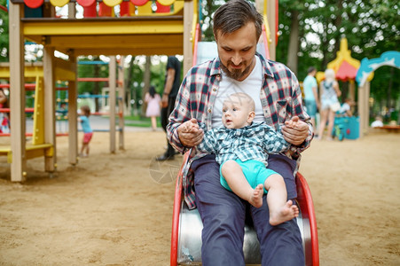 快乐的父母在夏季公园的游乐场与小宝玩耍爸和妈与男孩一起闲暇在森林中与孩子一起野餐快乐的父母与小宝一起在游乐场玩耍图片