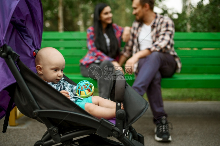 父母在夏季公园的长椅上享受小婴儿闲暇的快乐父母与男孩一起散步在森林中与孩子一起野餐家庭幸福父母与小婴儿一起在长凳上享受小婴儿闲暇图片