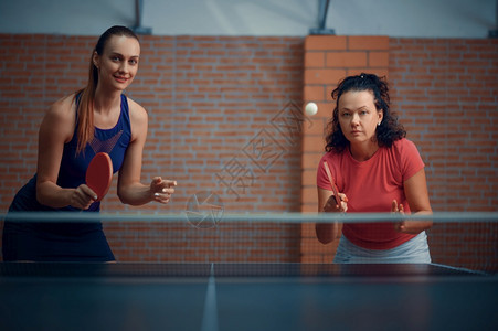 妇女打双桌网球乒乓在室内打桌玩游戏积极健康的生活方式妇女打双桌网球乒乓图片