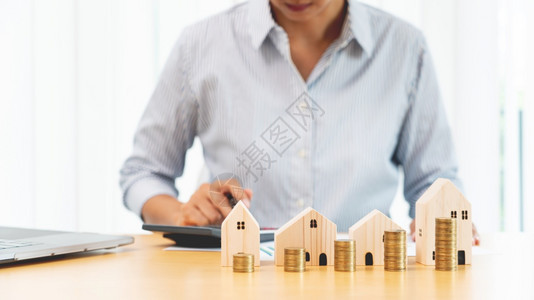 房地产投资和住抵押金融概念为房地产投资堆积硬币为购买住房或投机而储蓄的商人之手图片