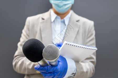 女记者佩戴防护手套和面罩在流行期间携带麦克风写笔记防止冠状新冠19疾病图片