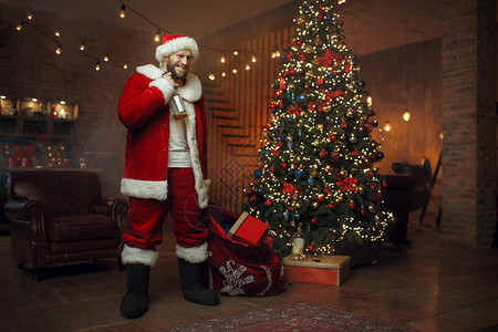 坏醉的圣诞老人会带礼物恶心的派对不健康生活方式在节日服装新年和酗酒中留胡子的男讨厌派对背景图片