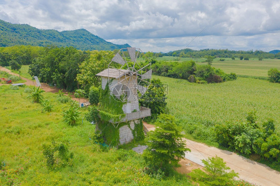 绿色风车或轮机在荷兰欧洲绿色草场和山地自然景观背电力生态能源和环境概念风格图片