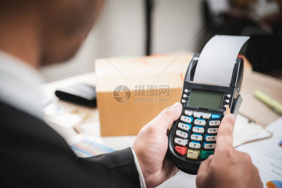 以信用卡支付的商人使信卡阅读机电子银行和网上商业营销概念图片